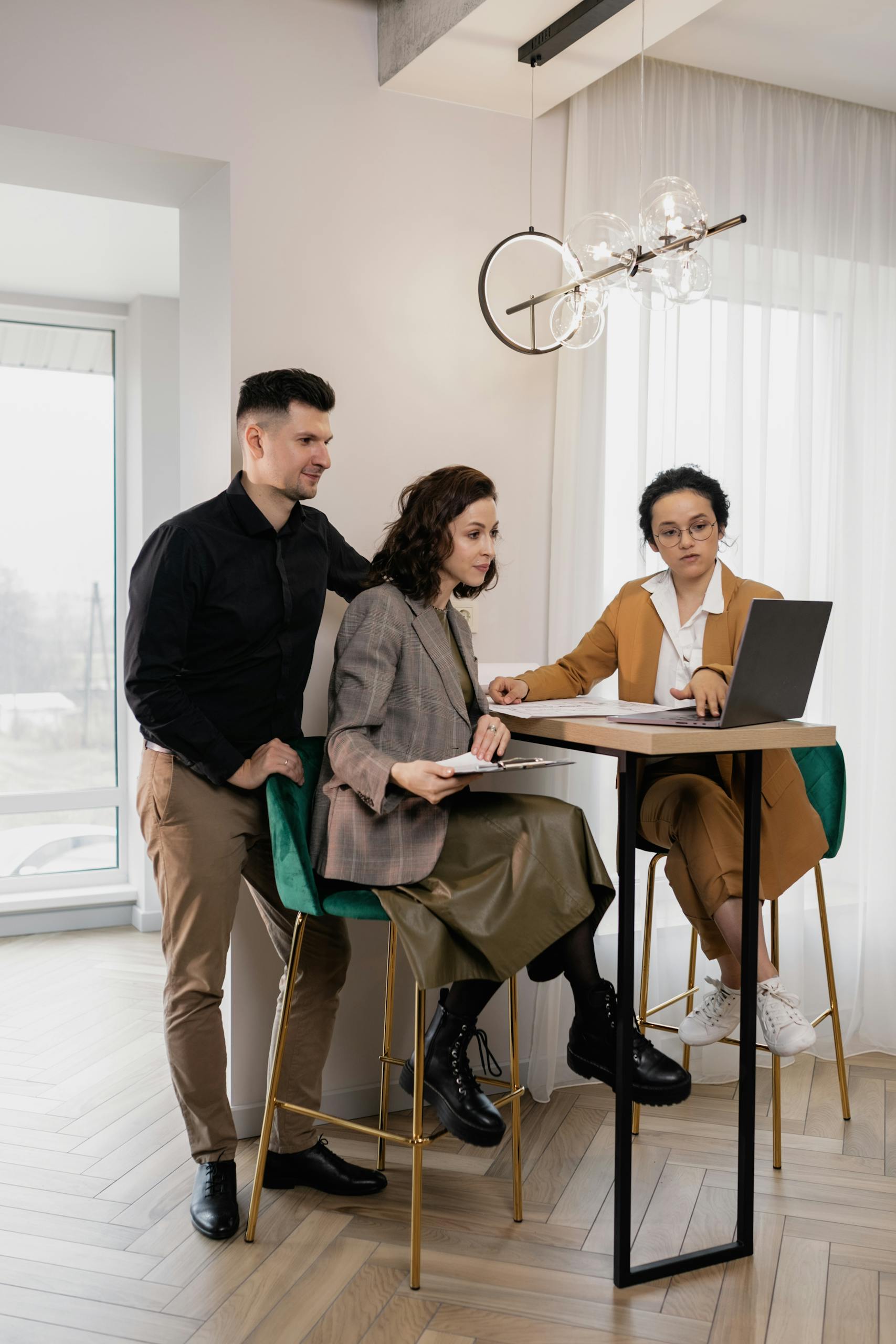A Woman Presenting to a Couple Using a Laptop